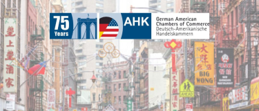 Faded shot of a street in Chinatown in NYC with an overlay of the German American Chambers of Commerce logo